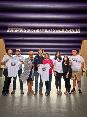TSB employees and students from Sevier County High School holding shirts that TSB handed out for the high school senior class of 2024
